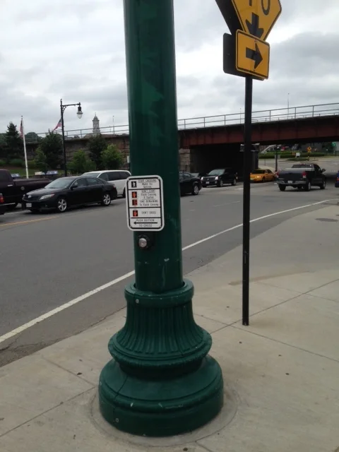 These kind of buttons for pedestrian crossings are the way of the dinosaurs. Get with the times, Worcester. Dan suggests we ditch these buttons in the areas we want to be pedestrian rich zones. Our lights can be on automatic sixty second cycles to give the pedestrians and cars shared turns for movement.