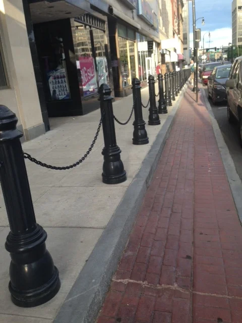 Bilevel sidewalks are the city's answer to ADA requirements of having a slope graded no more than 2%. These sidewalks split into two levels and place bollards to prevent people from falling off the first level. These sidewalks make it impossible for wheel chair mobility since handicap vans are forced to drop their ramps right up to the bollards. The only way to have ramp access is for the vans to move out into the street. Walk bike advocates are urging the city to apply for a waiver or raise the street up eight inches.