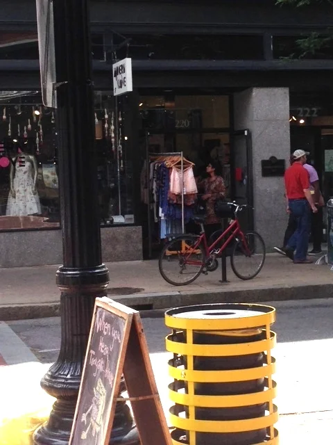 See the bike parked outside of this clothing store. Walkers and bikers were everywhere on the streets. Cars did not speed past, drivers watching out for pedestrians and scanning what was happening outside on the streets.