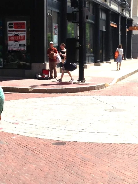 A hint of active street life: A musician plays his accordion on the busy sidewalk.