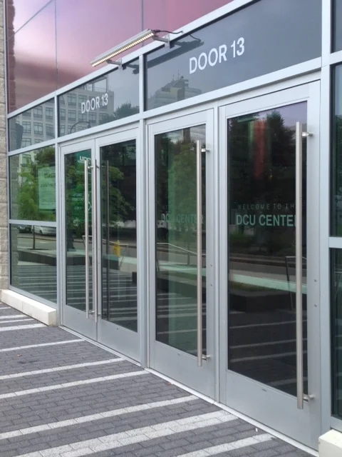 I counted 27 doors leading into this facility. All of them were locked, of course, because nothing is happening here right now. It's the middle of the workday. This block is lifeless - no street traffic, no signs of pedestrian life, nothing. I'm walking around this building and I am all alone.