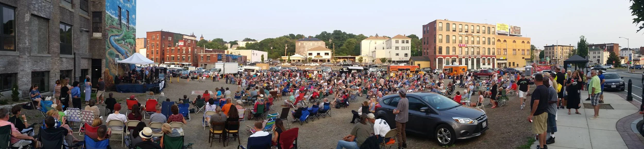 This parking lot is for the people (!) at a summer evening Wednesday music concert outside of Crompton Place. Note the mural on the left side depicting this neighborhood's link to the industrial history of the Blackstone River canal.