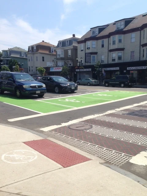 Somerville is light years ahead of Worcester in buildling biking infrastructure. Dedicated bike lanes are all over the city streets. Check out what we found here -- bicylists get a head start and wait for lights in front of the cars in their own painted bike boxes. I'm reminded of the phrase labeling bike lanes as "white lanes of gentrification". Don't ever believe that having kids means you have to tool around in a mini-van. Joel bikes everywhere with his family. When they were babies, Joel transported his kids in his bike trailer. Now that they are older, the kids explore the city on their own bikes. As hard core bike activists, Joel and his partner, Lynn were instrumental in the development of converting a n old railroad line to a community bike path from Davis Square in Somerville to Alewife and beyond. 