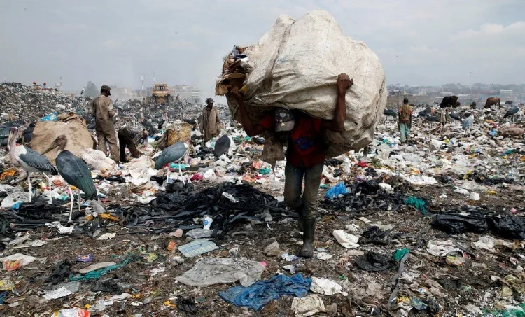 In Kenya, a man carries a big sack at the country's biggest dumpsite in the capital, Nairobi, ahead of a ban on the use of plastic bags. August 2017, Reuters (source)