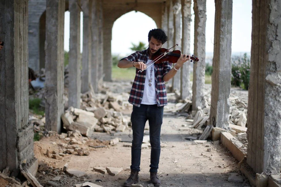 Ameen Mukdad, a violinist who lived under so-called Islamic State for two-and-a-half years, performs at Nabi Yunus, a shrine in eastern Mosul, Iraq, following liberation, 2017. MUHAMMAD HAMED / REUTERS ( source )