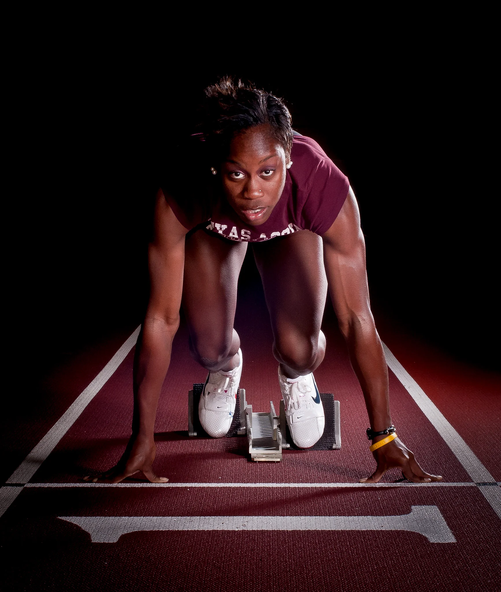 Senior Jessica Beard, medalist sprinter in the 4x400m at the 2009 Olympics, takes her mark on the starting block, Feb. 1, 2011. As a graduating senior on the Texas A&M University Track & Field team, Beard was named as the Distinguished Letterman of