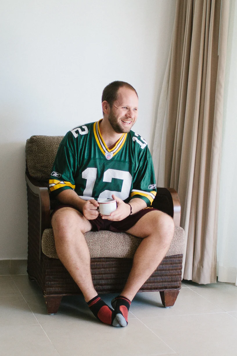 Punta Cana destination wedding, groom wearing football jersey casually drinking coffee