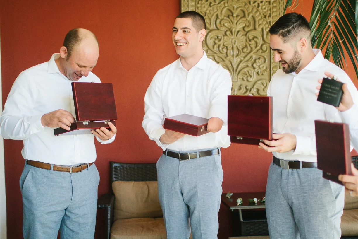 Punta Cana destination wedding, groomsmen open their wedding gifts with excitement