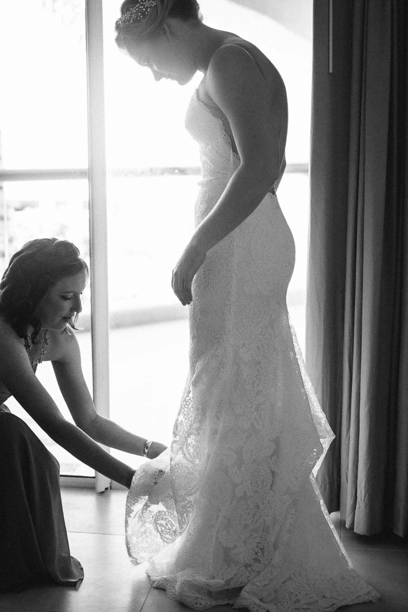 Punta Cana destination wedding, maid of honor helps bride into her wedding gown