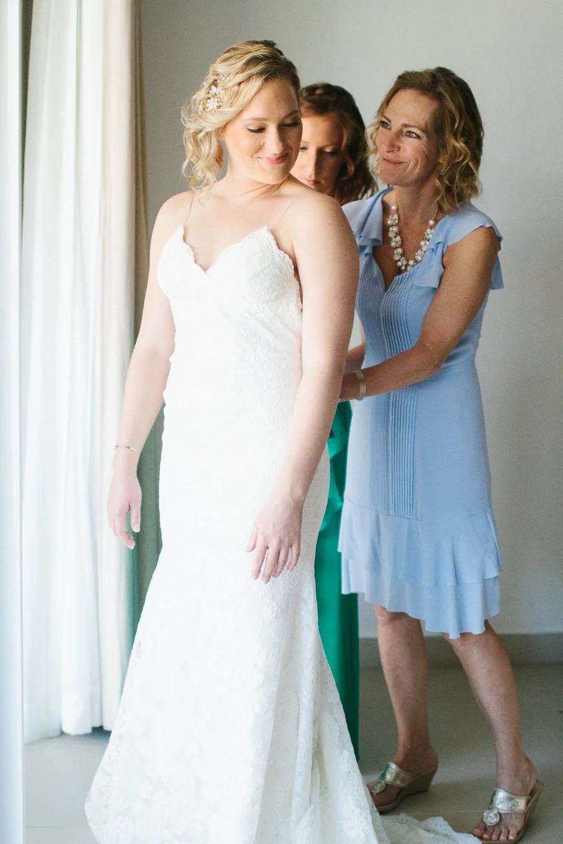 Punta Cana destination wedding, mother of the bride helps her daughter into her wedding gown