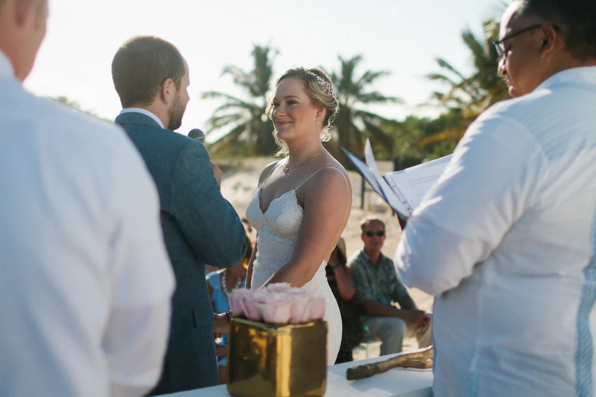 Punta Cana destination wedding, beach front wedding ceremony at sunset, bride begins reading her vows