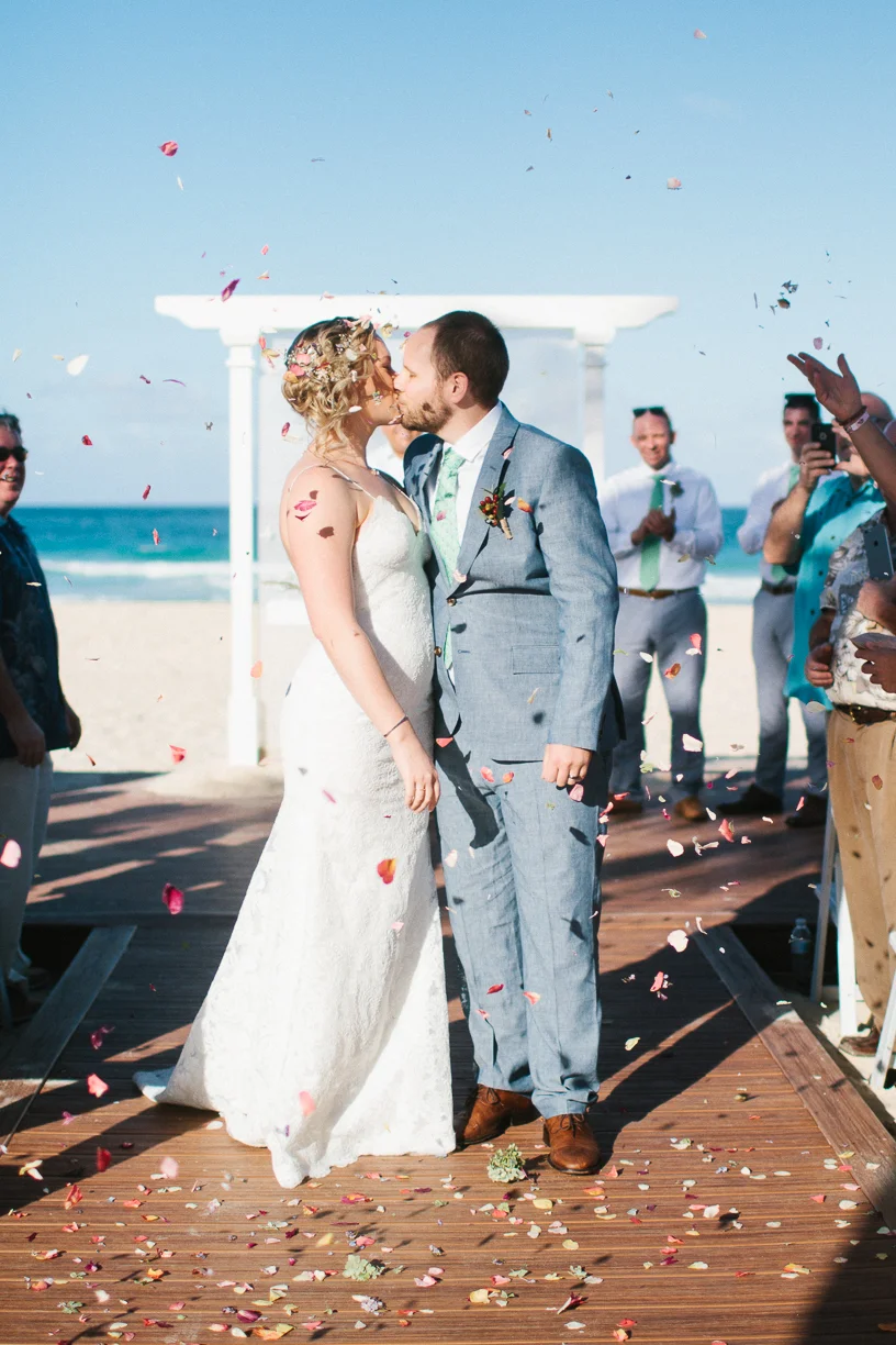 Punta Cana destination wedding, beach front wedding ceremony at sunset, bride and groom celebrate with a kiss
