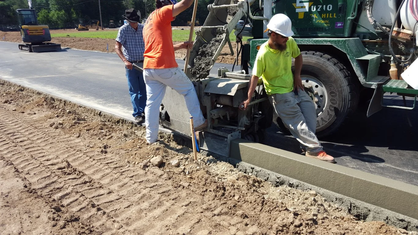 Extruded concrete curb being installed.
