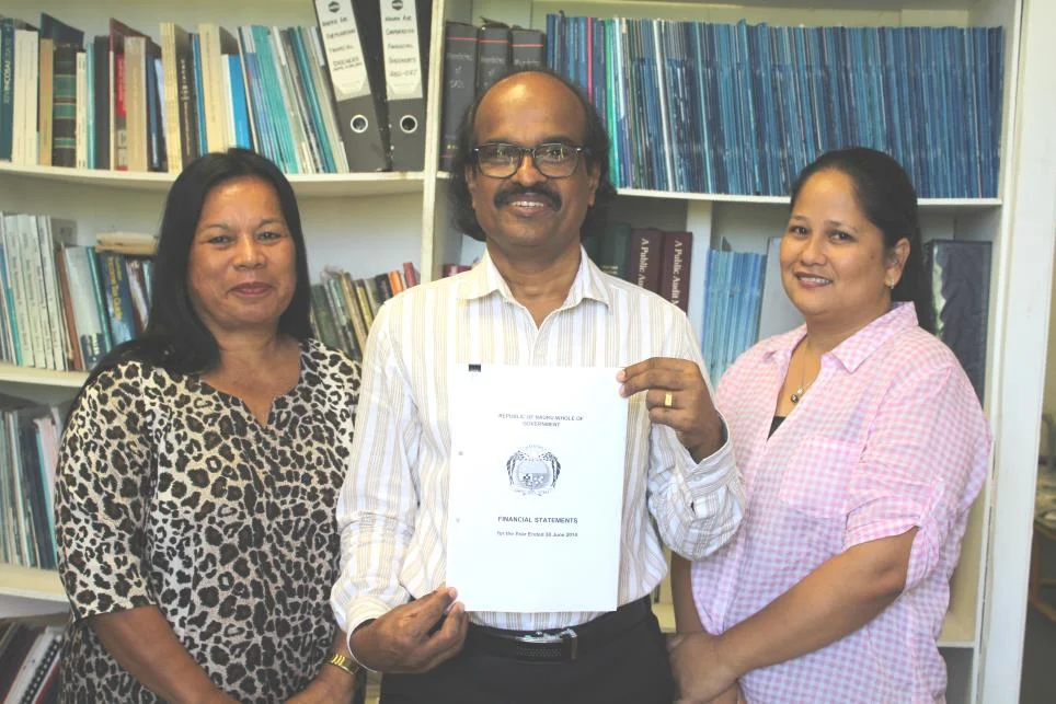 Auditor General of Department of Audit Nauru Mr Manoharan Nair holding the 2013/2014 Financial statements which includes his independent audit report, with his two audit staff Ms Gillian Itsimaera and Ms Valeni Natano