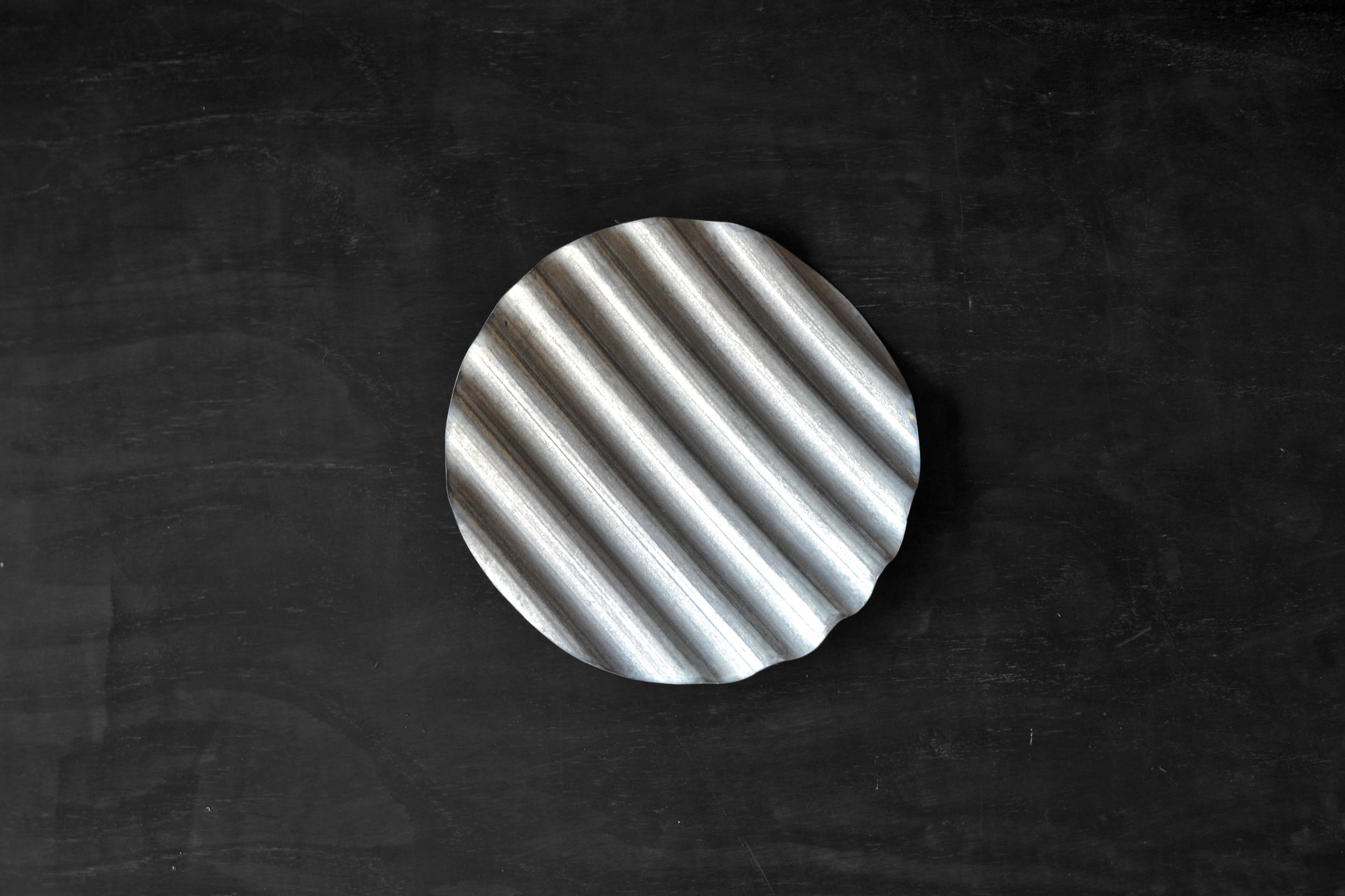 Corrugated metal is a very iconic material to the South African landscape and is found in traditional, contemporary and informal architecture. One of the main topics we explored whilst working with this material, was how to lift the negative associations attached to this beautifully graphic material. At the Bijou, artist Conrad Hicks' studio, we experimented with the material with various techniques like rolling, folding, soldering and riveting. We felt the production should be kept simple and accessible as these are some of the qualities which make this material so widespread. We also worked alongside local businesses and craftsmen who shared a common affection to this material to produce the prototypes.