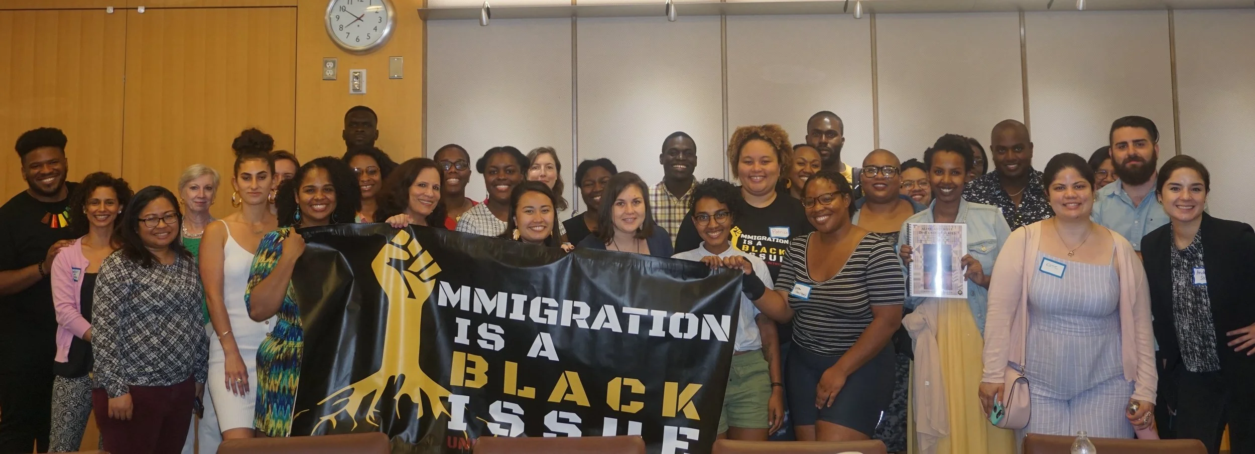 Pictured above is a group photo of attendees from the Alive and Well Discussion Series launch, which took place in Washington DC on May 30, 2019. The people in the front row are holding a banner which says “Immigration is a Black issue.”