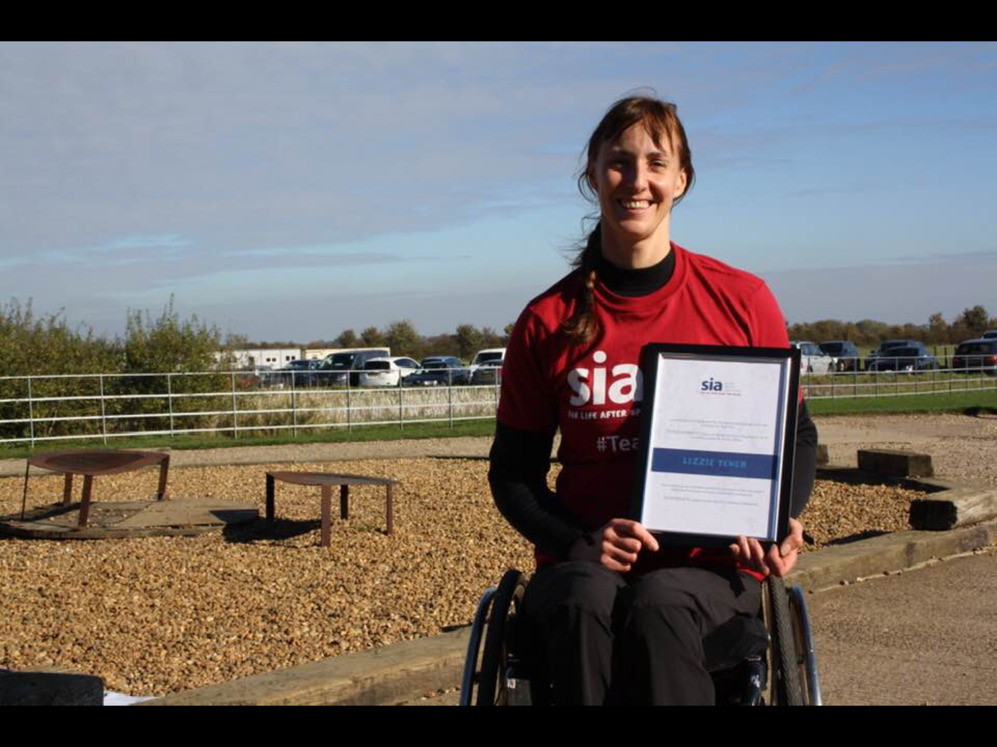Lizzie - back on the ground, proudly showing off her ‘top fundraiser’ certificate