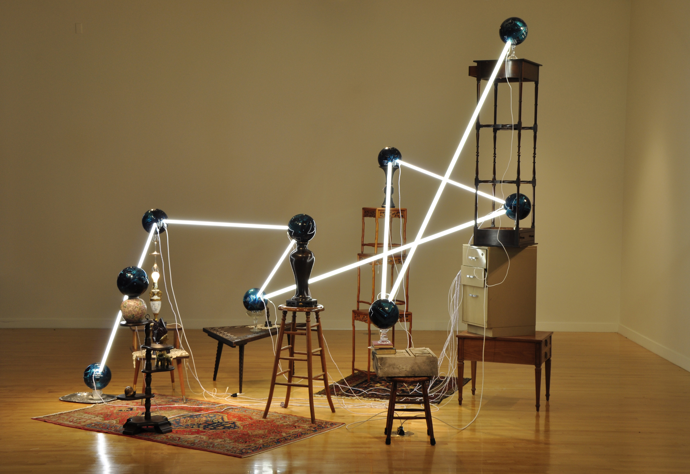   Alejandro Almanza Pereda © 2011 ,&nbsp;S pare the rod, spoil the child .&nbsp;Fluorescent light bulbs, bowling balls, lamp, books, tatted doilies, textiles, wood Polynesian bust, electric cords, glassware, ceramics, wood side and coffee tables, met