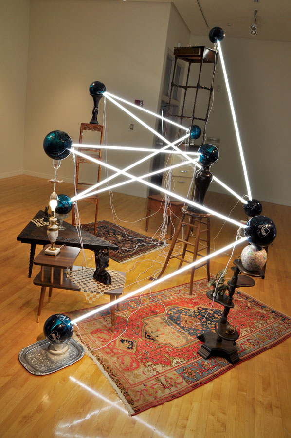   Alejandro Almanza Pereda © 2011 ,&nbsp;S pare the rod, spoil the child .&nbsp;Fluorescent light bulbs, bowling balls, lamp, books, tatted doilies, textiles, wood Polynesian bust, electric cords, glassware, ceramics, wood side and coffee tables, met