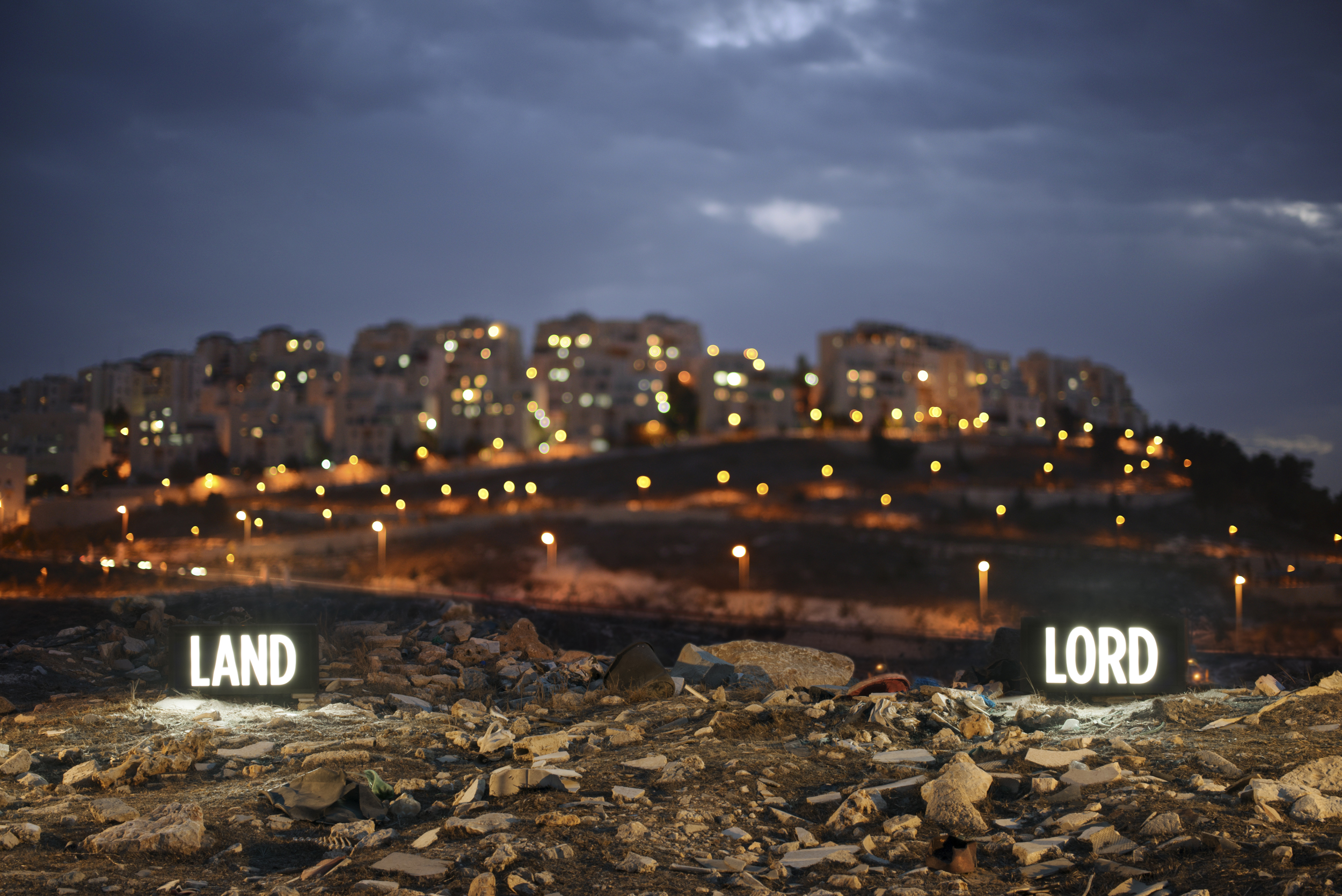 Image above: ©Shimon Attie, LAND LORD, Two on-location light boxes, looking onto the Israeli settlement Har Homa from the Palestinian Village Umm Tuba, annexed by Israel in 1967, 2014 digital c-print / Courtesy of the artist and Jack Shainman Gallery, New York.