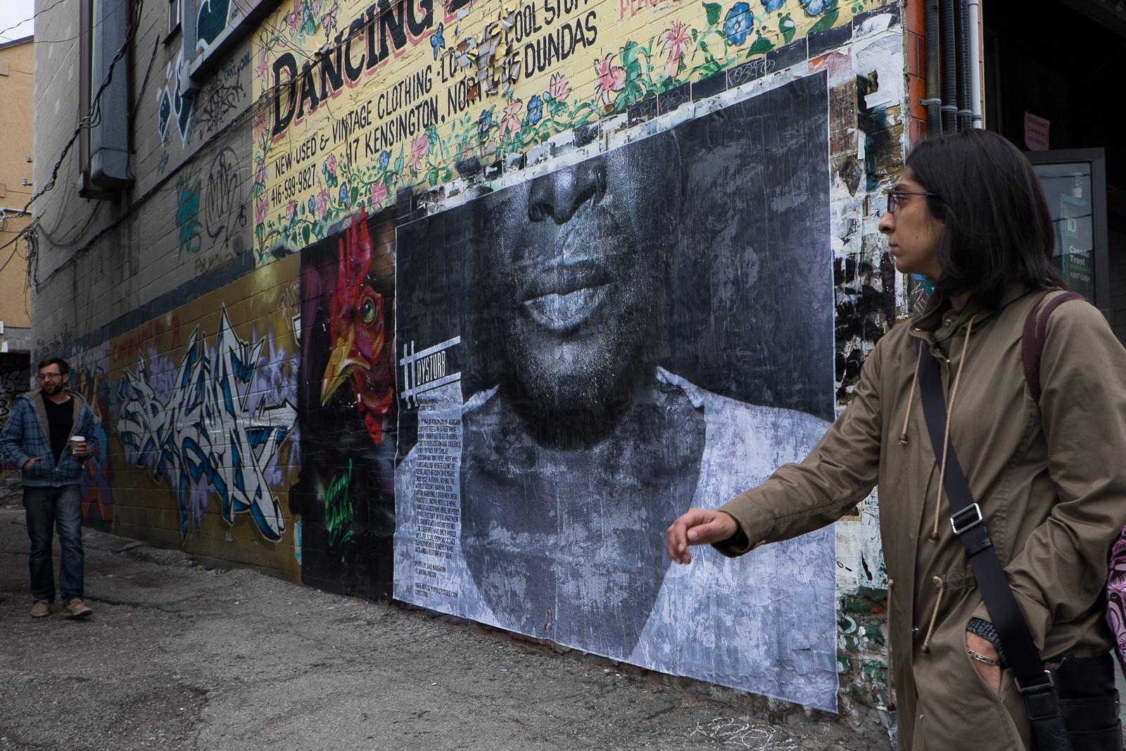 ©Justin Mignot. For #Contact16, we pasted ©Jake Naughton's photograph at 56 Kensington Ave, Toronto. The caption reads: Nairobi, Kenya. June 17, 2015: S. is one of hundreds of African LGBT refugees who flee their home countries to go to Kenya due to persecution and violence, only to face the similar discrimination there. Most will eventually be resettled in the West, but that can take years. They wait in Kenya, hoping the worst doesn't happen. Soon after arriving, seven men with machetes broke into S.'s home and attacked him. Here, he poses for a portrait in the apartment he shared with his boyfriend (though they have since moved), with one scar from the attack clearly visible. Others on his face and chest are not seen.