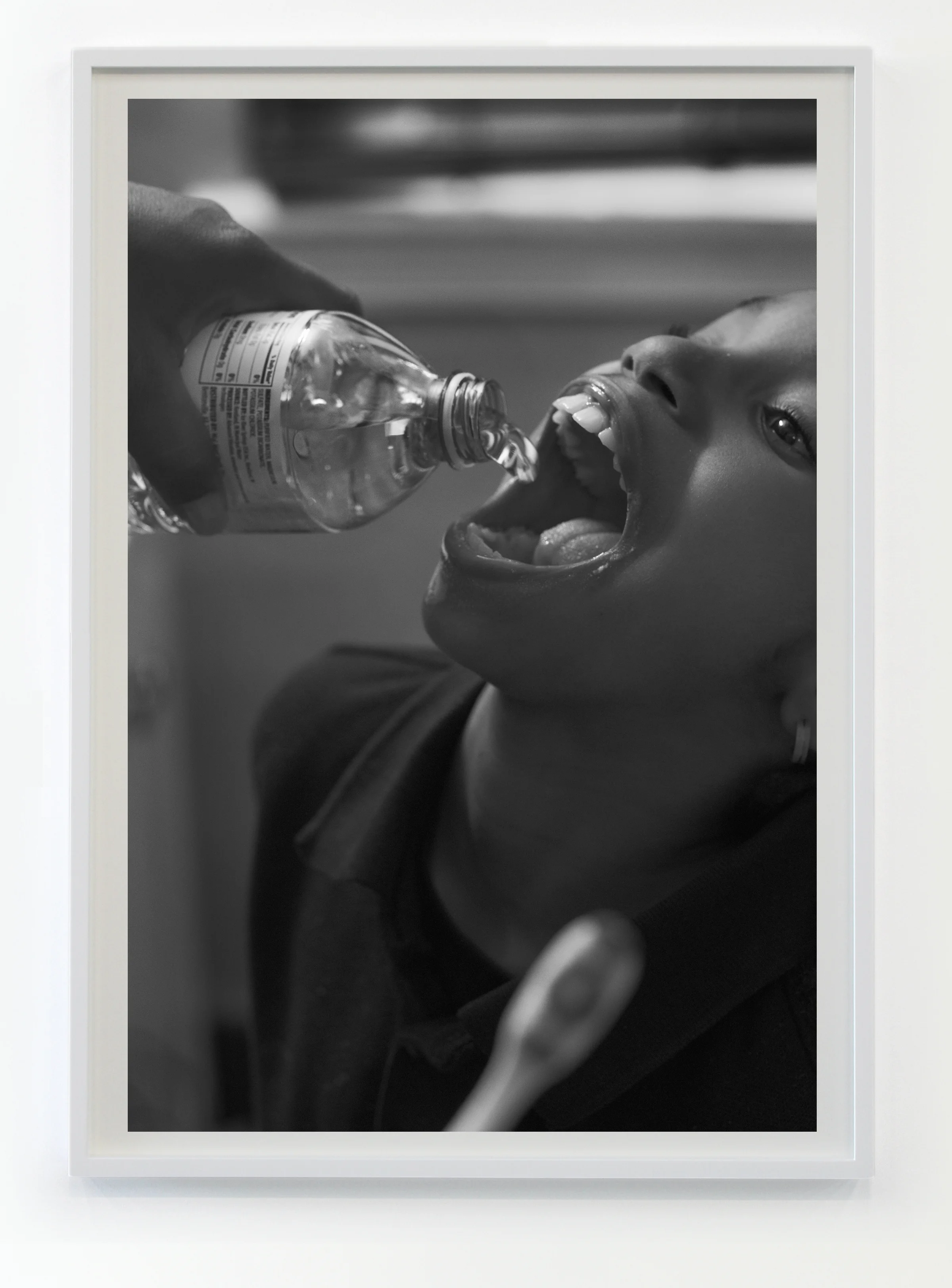 Shea Brushing Zion's teeth with bottled water in her bathroom, 2016/2017 © Latoya Ruby Frazier