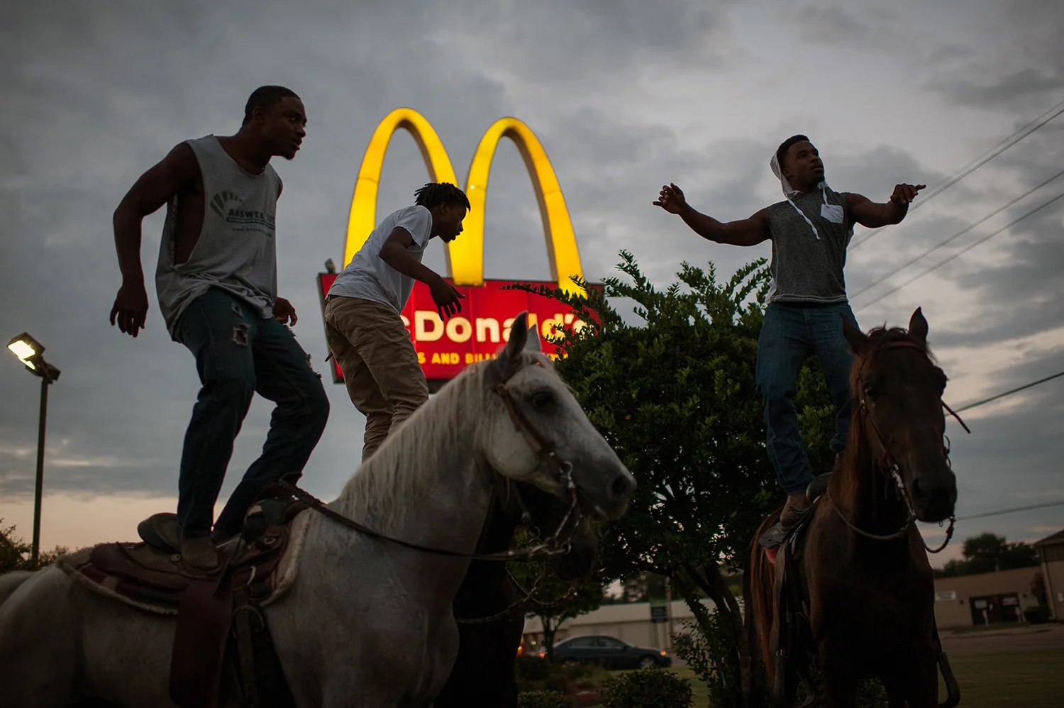A group of young cowboys dance atop their horses outside McDonald's in Cleveland, Mississippi. Photo by Rory Doyle.