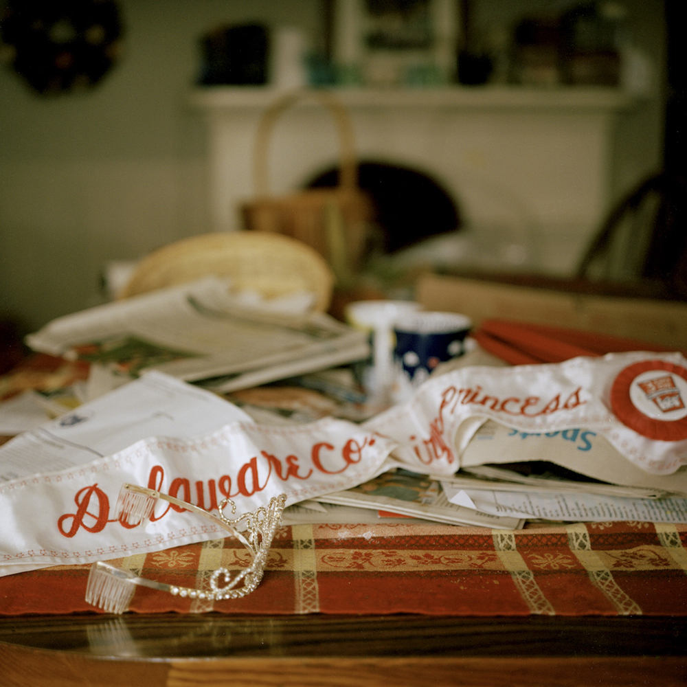 "Dairy Princess." Miquela Hanselman's Delaware County Dairy Princess sash on the dining table of her home. Miquela is the youngest of seven children, three of whom currently work on their parent's farm, Del-Rose Farm © Tess Mayer