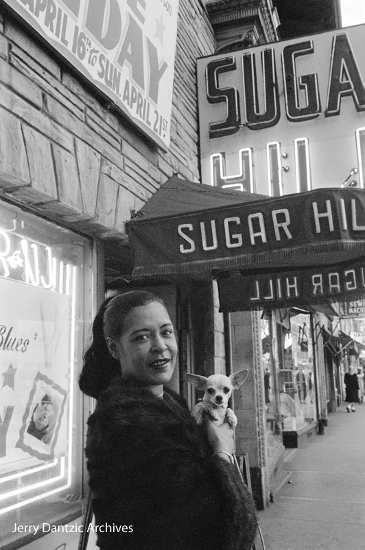 Jerry Dantzic, Billie Holiday holding her pet Chihuahua, Pepi, in front of Sugar Hill, Newark, New Jersey, April 18, 1957. © 2017 Jerry Dantzic/Jerry Dantzic Archives. Courtesy Thames & Hudson