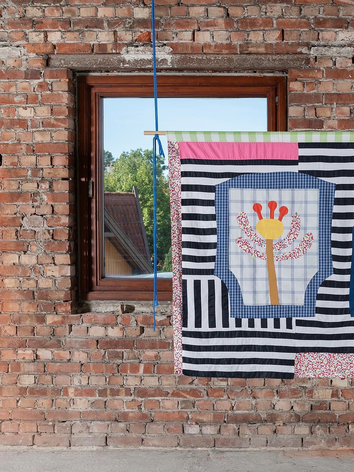 Katrine R&oslash;rbakken Lund
&laquo;Strekk kronbladene dine mot sola og la felte tårer vanne nye spirer&raquo;
Patchwork og applikasjon av gjenbrukte bomullsstoffer (kl&aelig;r, duker og senget&oslash;y), nylon og furu
135 x 195 cm
2023

Fra utstil