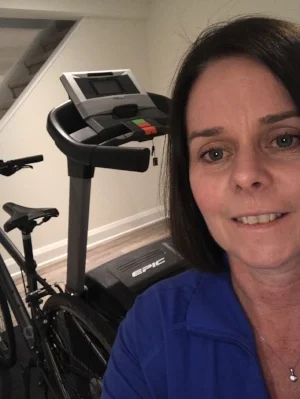 Brenda smiling as she shows her basement workout area. This is where she's spent a lot of time putting in the hard work to get where she is. 