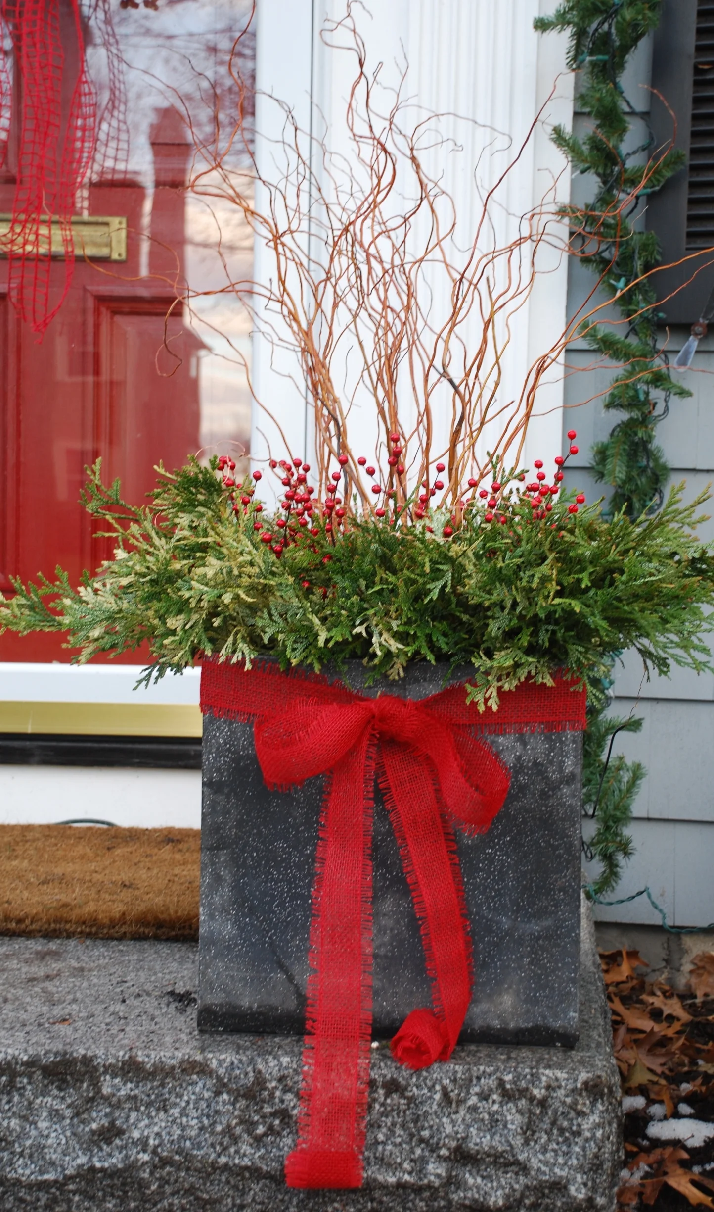 Winter container garden with greens, berries and twigs