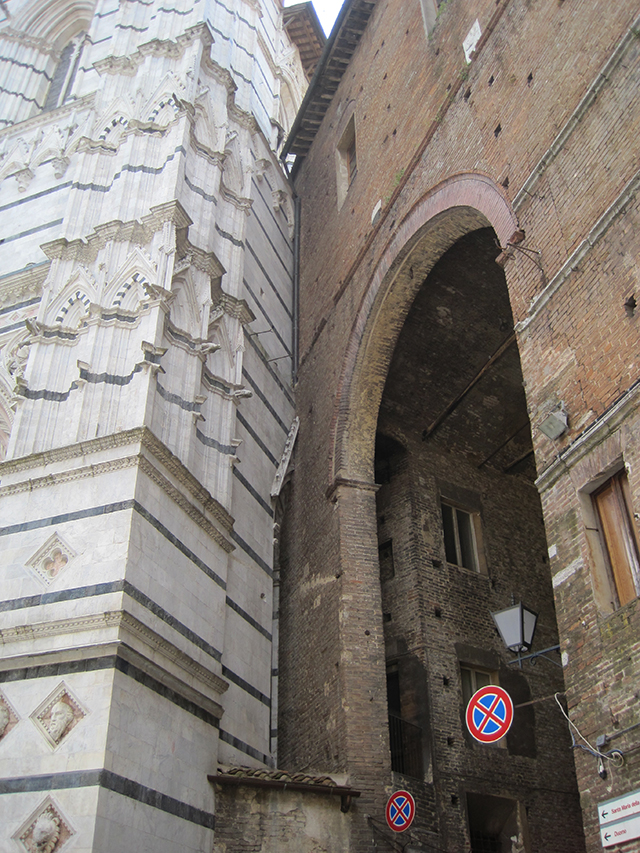 Brick buildings butt right up against the Cathedral – Siena.