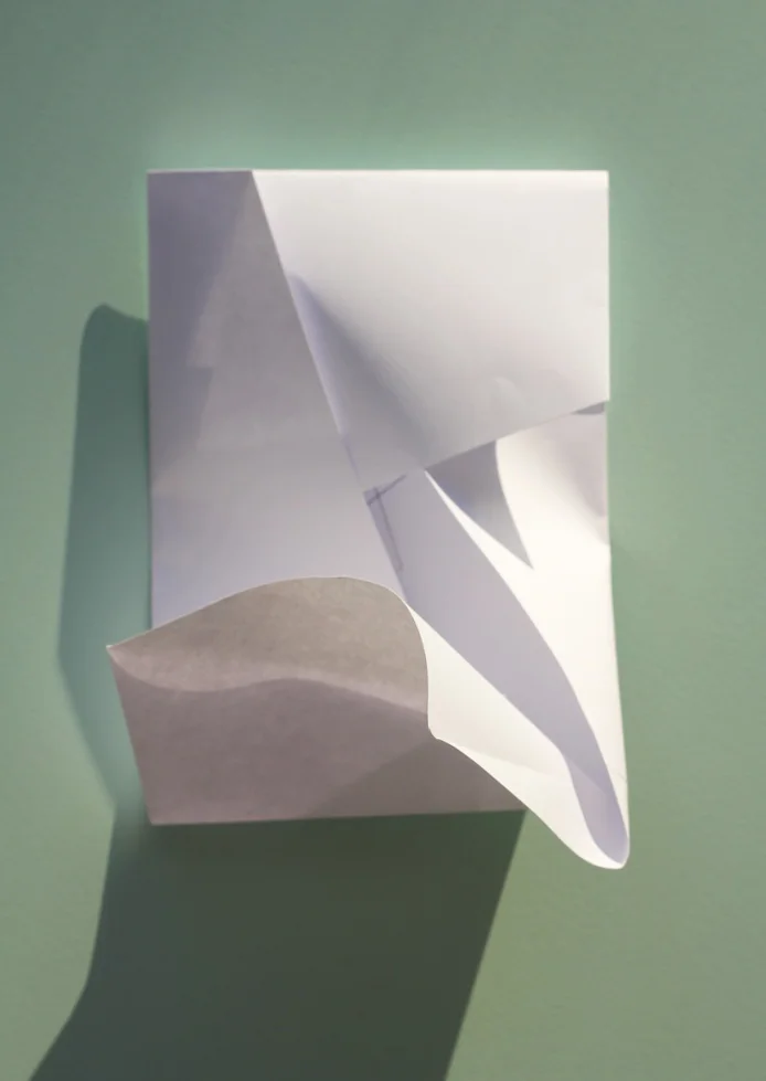 Fold den anden kortside ind mod midten og gør plads til at hjørnet kan skubbes ind og lukke konvolutten. (Samme princip som med en papkasse).