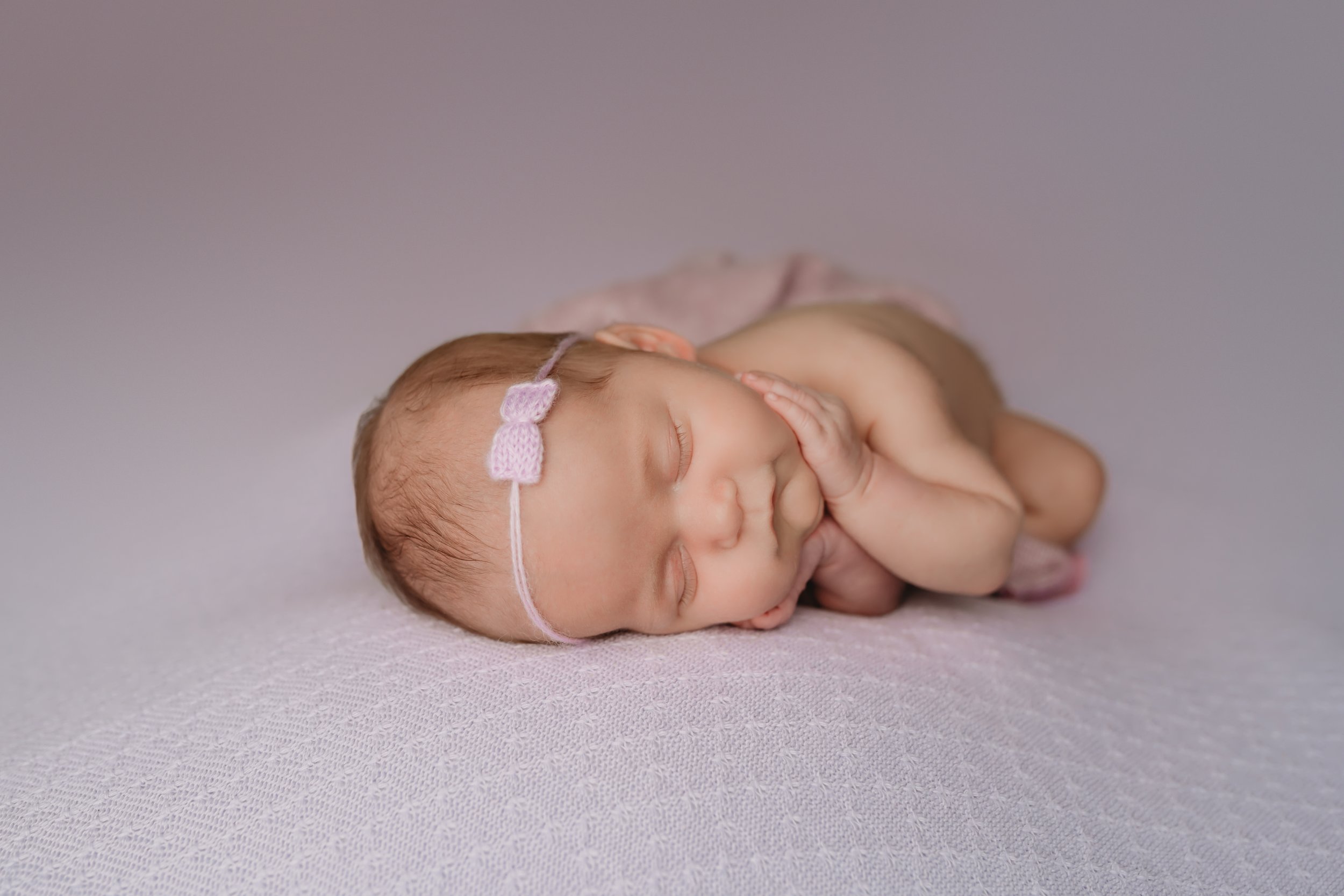 Boca-Raton-Newborn-Photographer-Baby-in-purple-with-face-in-hands