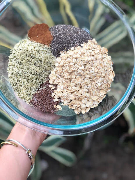 I love this recipe because again, it’s simple and you can truly add whatever “extras” you have in your pantry. Start with the dry stuff. Here we have oats, hemp hearts, chia seeds, flax seeds, cinnamon, collagen and Catie’s Greens.
