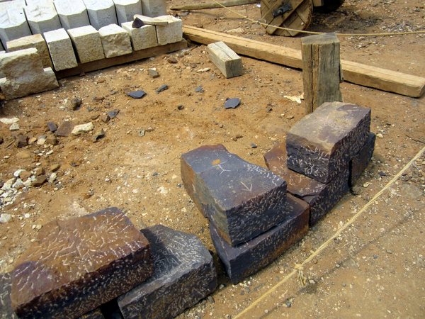 Sandstone that has been selected for a specific purpose and dressed appropriately. Arrows mark the direction of the outside face. Each stone is signed by the stonecutter so the quality of the work can be monitored and appropriate payment can be made. Limestone sits, dressed and ready, at the top of the photo.