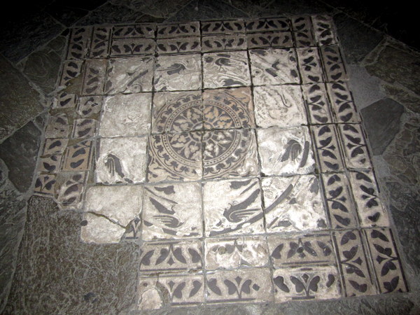 An ancient mosaic on the floor of an entranceway, worn from the treading of thousands upon thousands of feet.