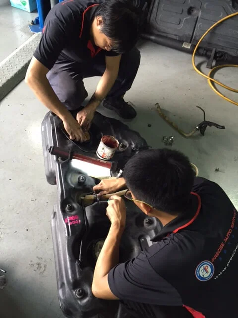 Our diligent mechanics working on the fuel tank.