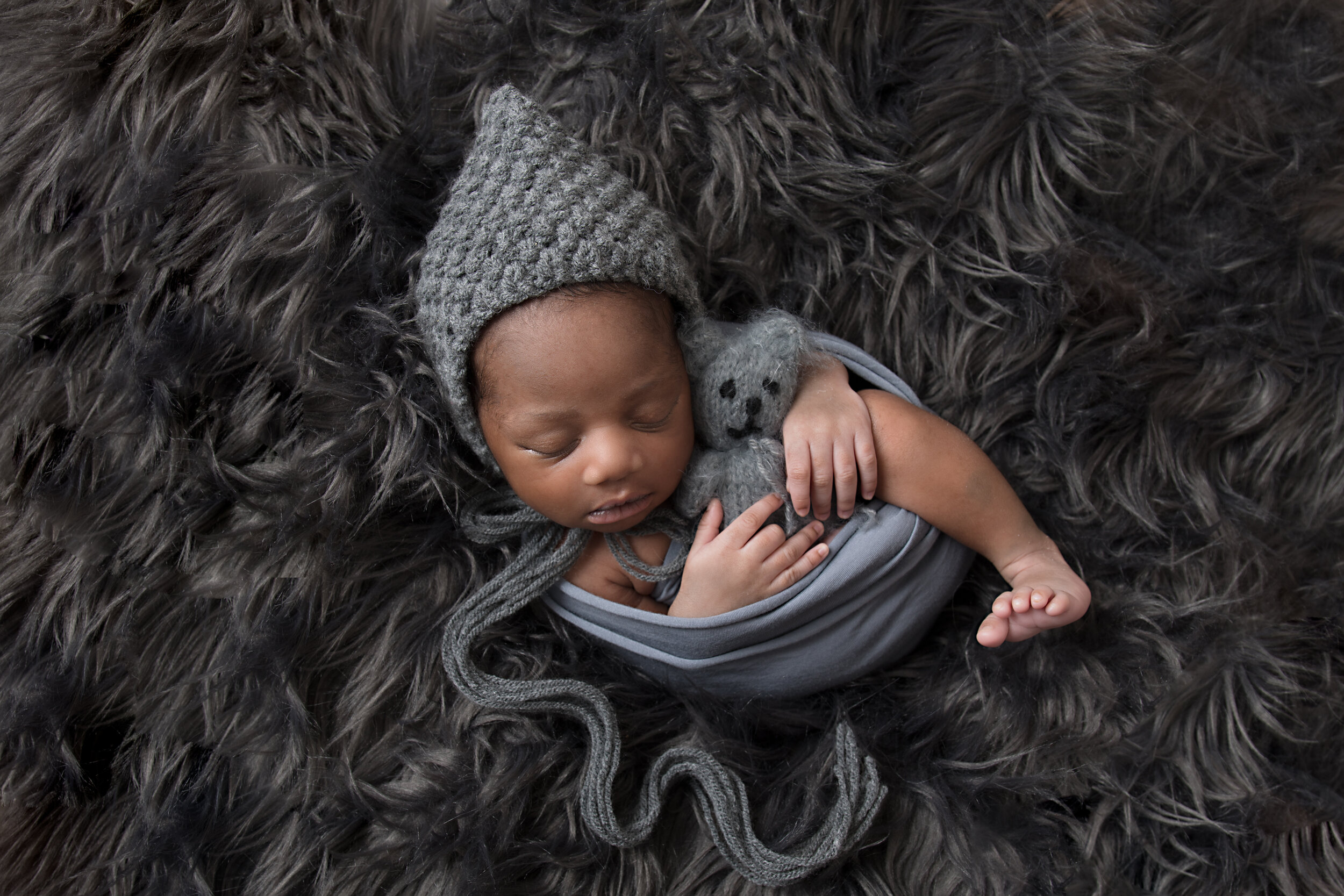  Sleeping newborn boy holding teddy in MK 