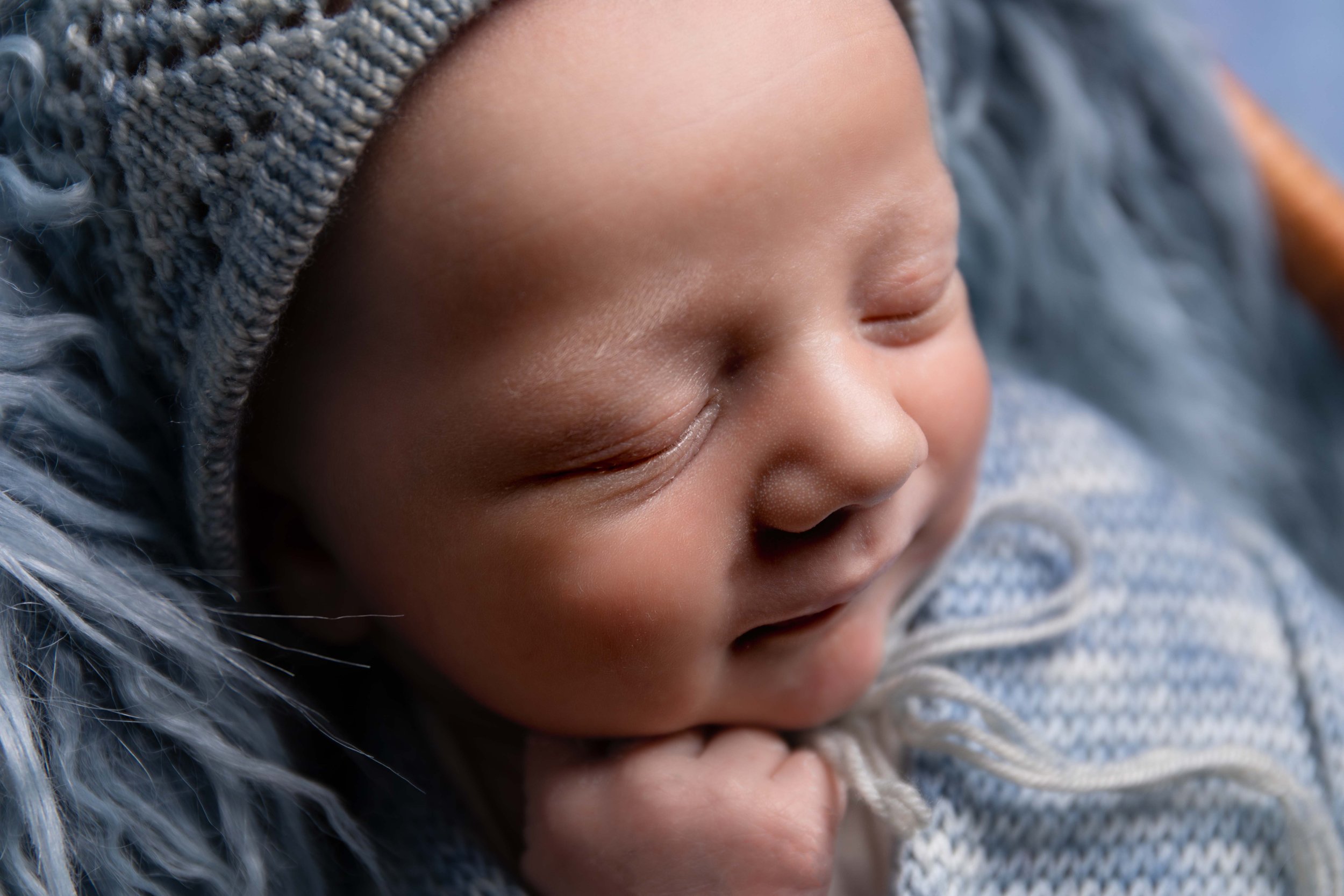  Newborn boy sleeping in his sleep in blue hat in Bedford 