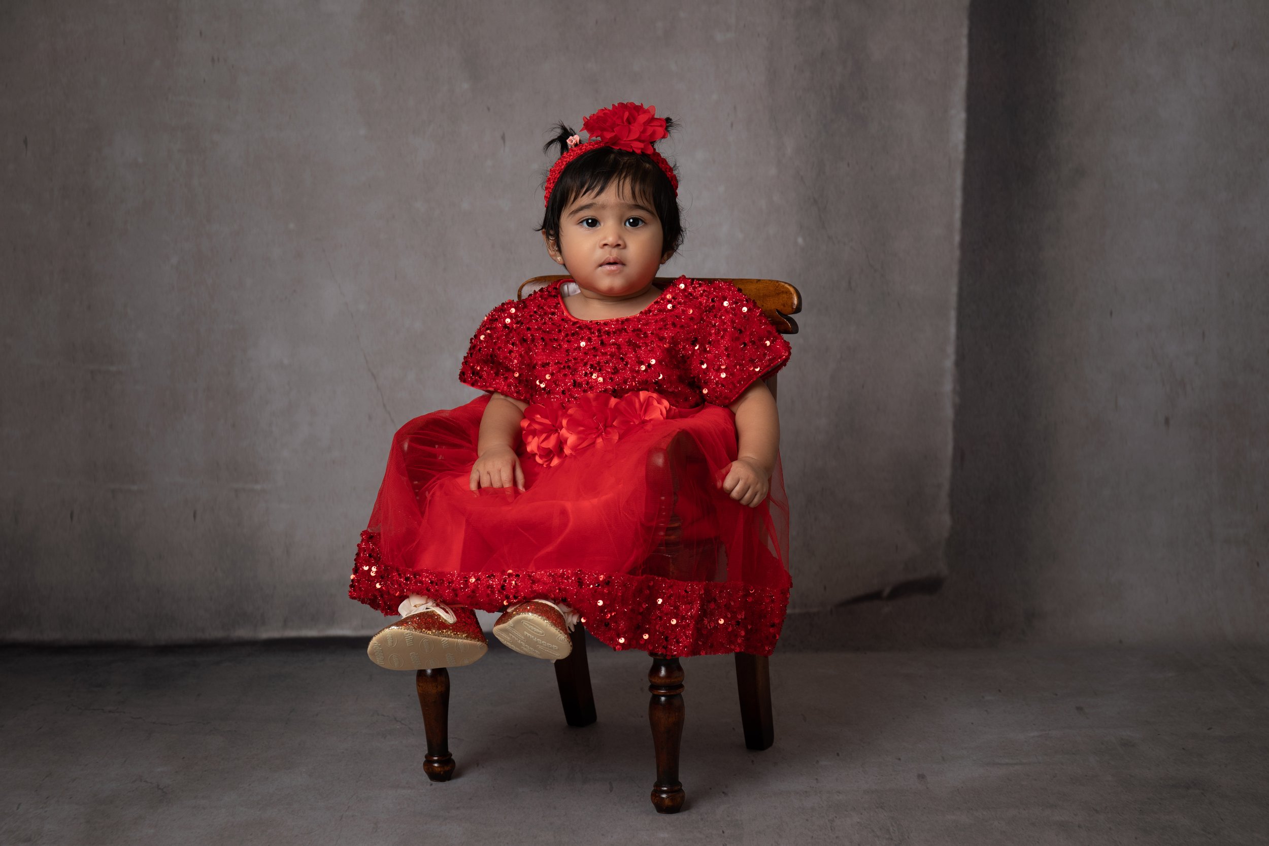  Baby girl in a red dress sitting on a chair in Milton Keynes Studio 