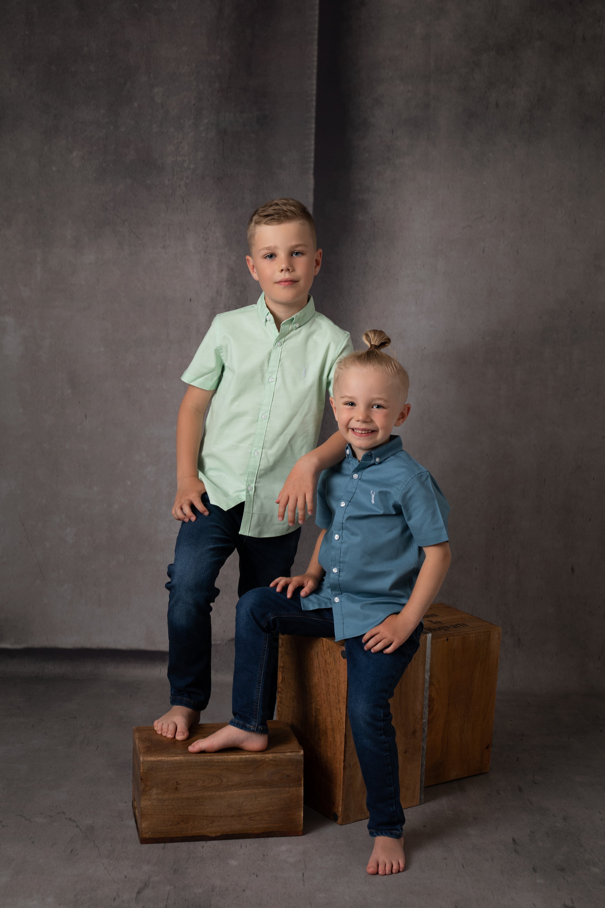  Two brothers wearing shirts posing in photograph in Milton Keynes studio 