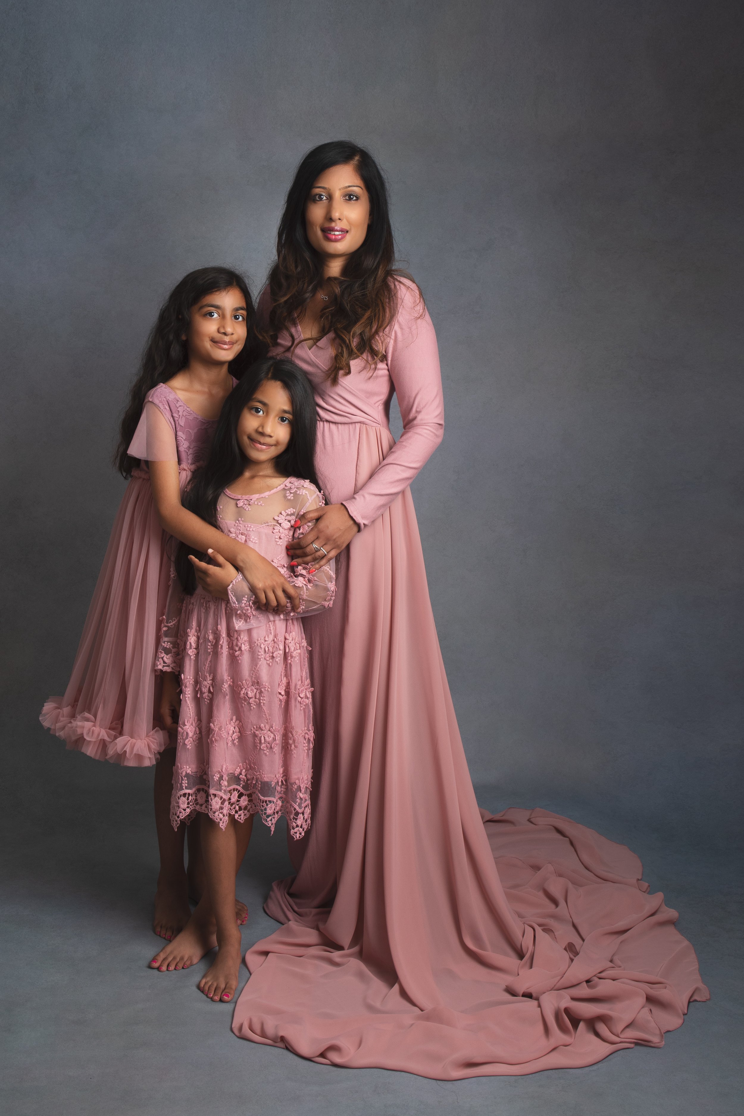  Mum and two daughters wearing pink dresses posing in MK studio 