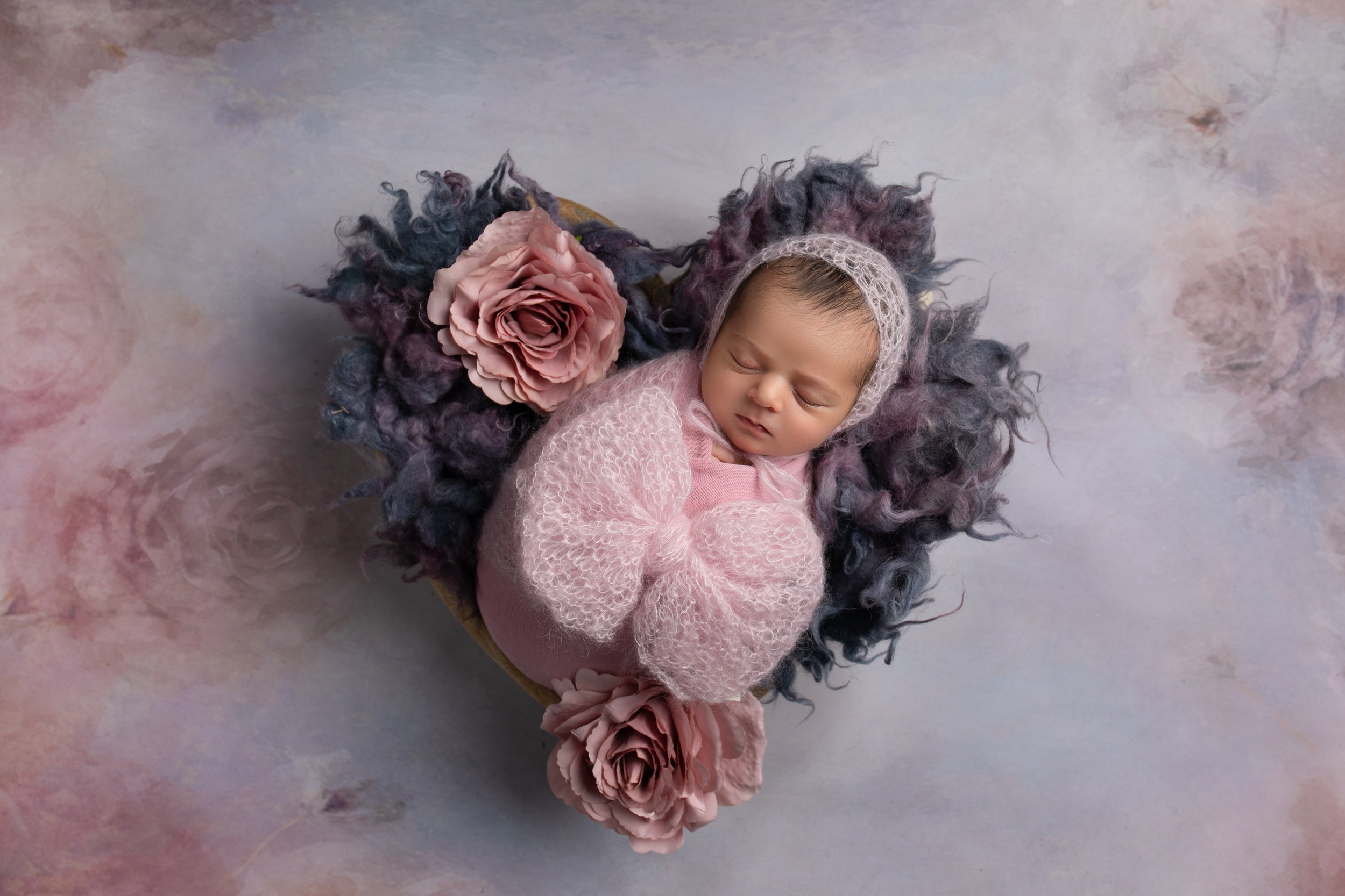  Newborn girl in a heart bowl wrapped in a pink bow in Northampton 