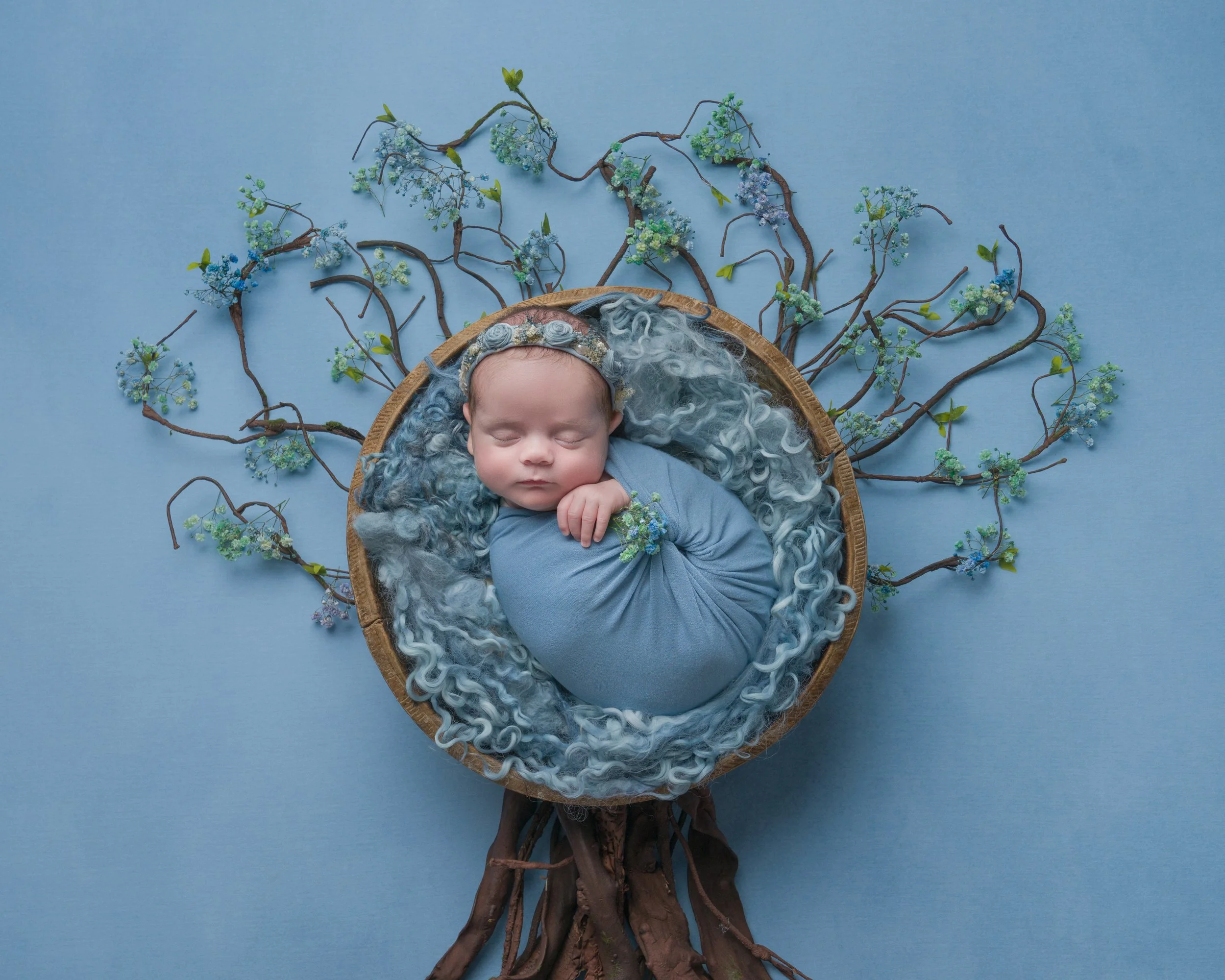 Newborn baby in a pretty swaddle with flower tree Milton Keynes
