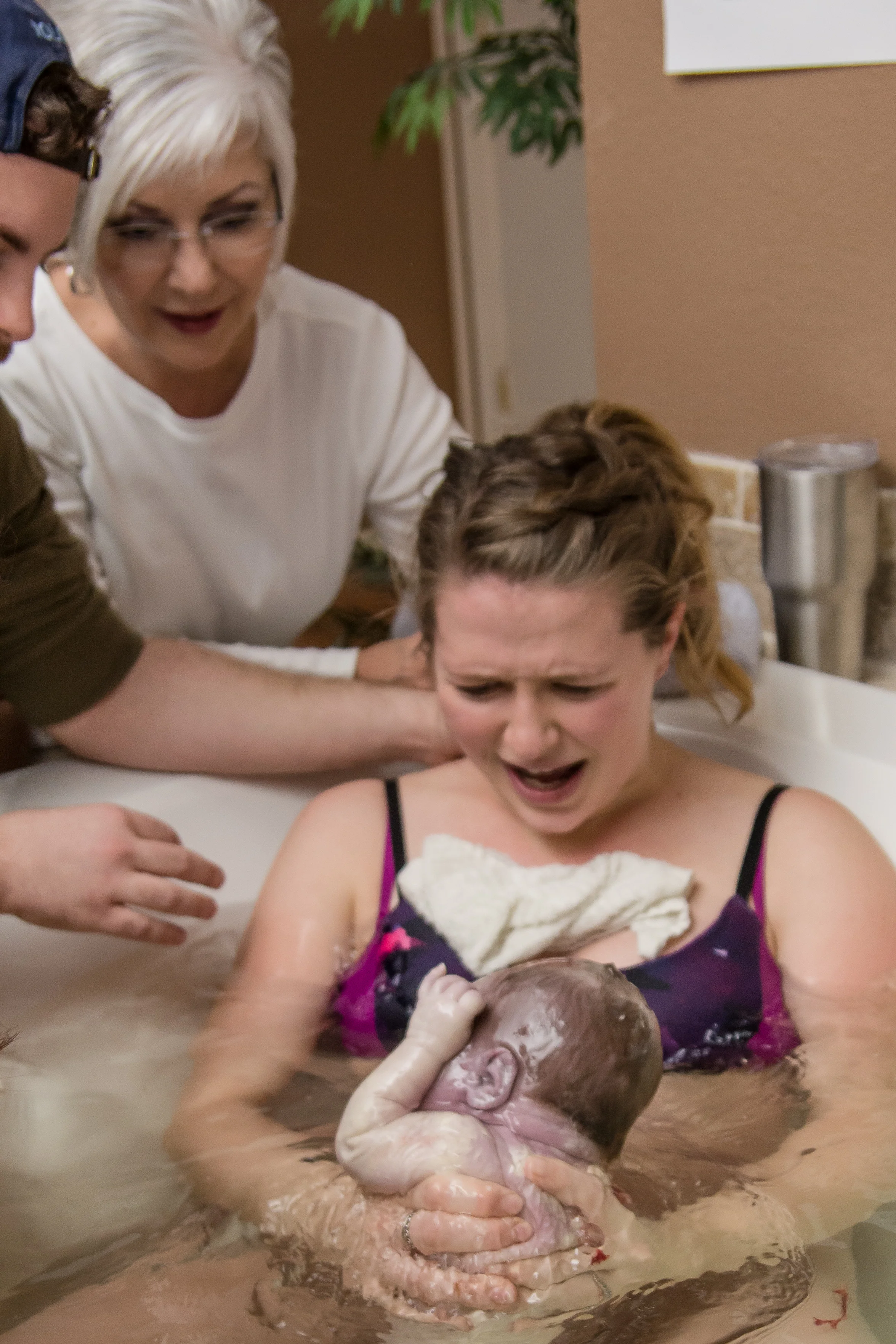 birth-photographer-mom-delivers-and-pulls-baby-out-of-water-in-birth-tub.jpg