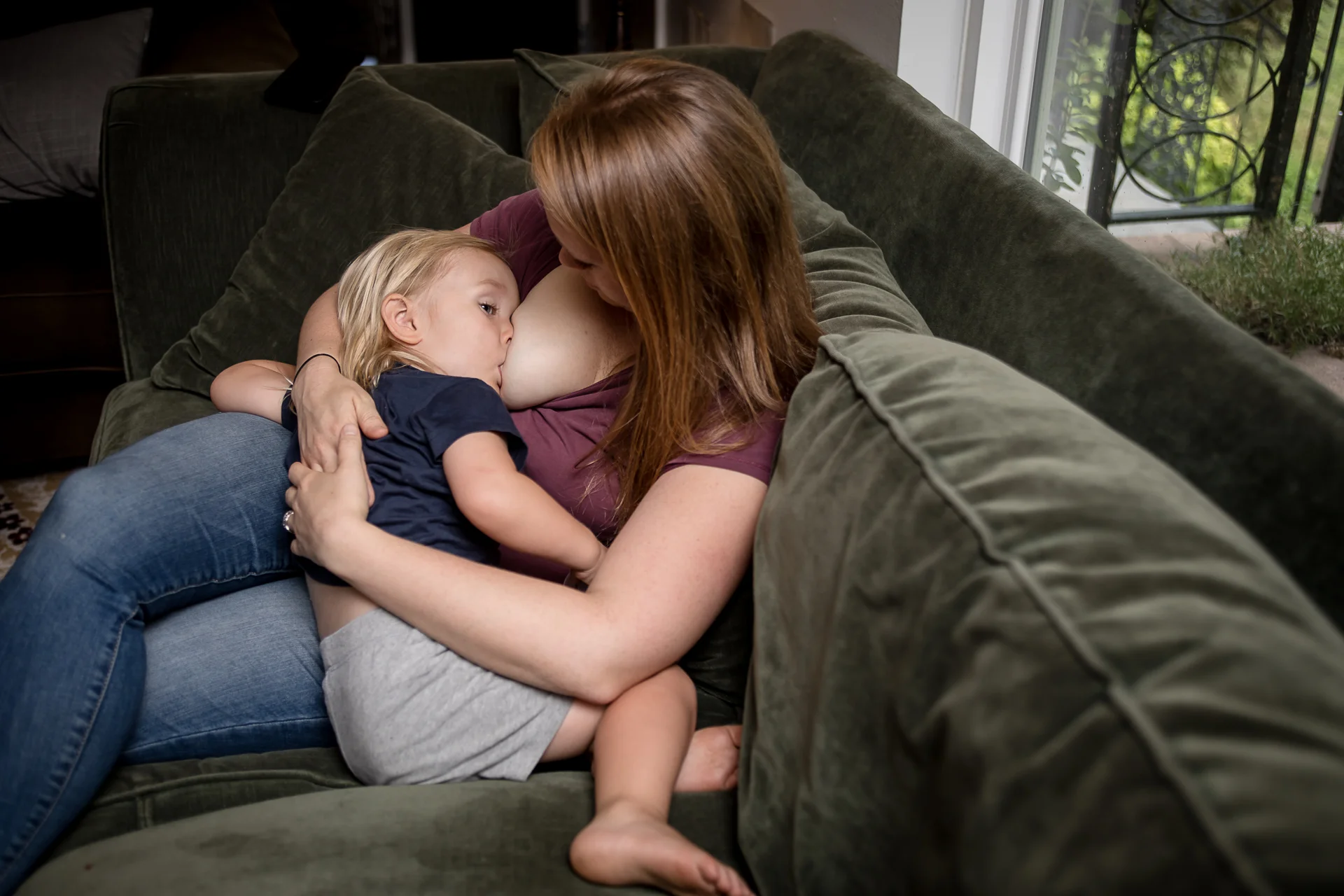 Photo of the beautiful Sarah Tilford of Modern Village Midwifery nursing her toddler son.