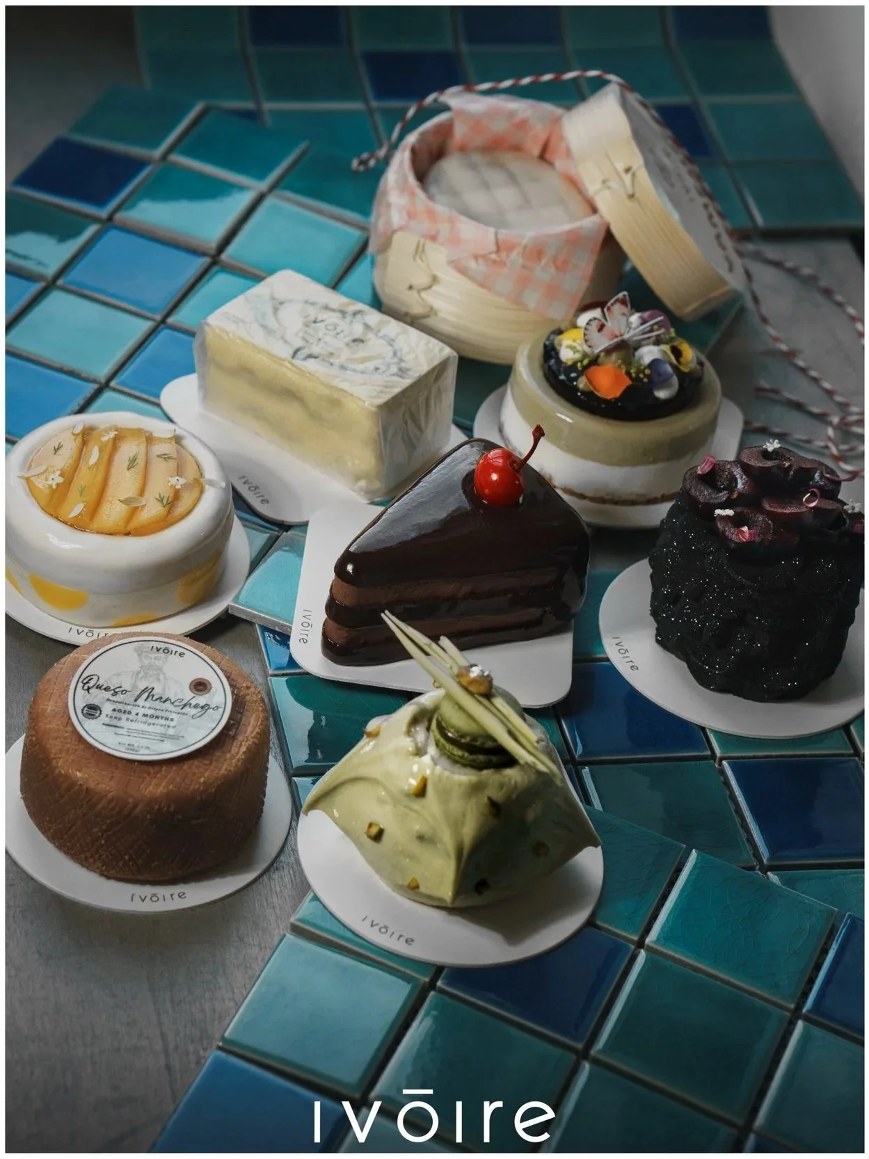 A display of different types of food, some are made to look like cakes, others are blocks of cheese