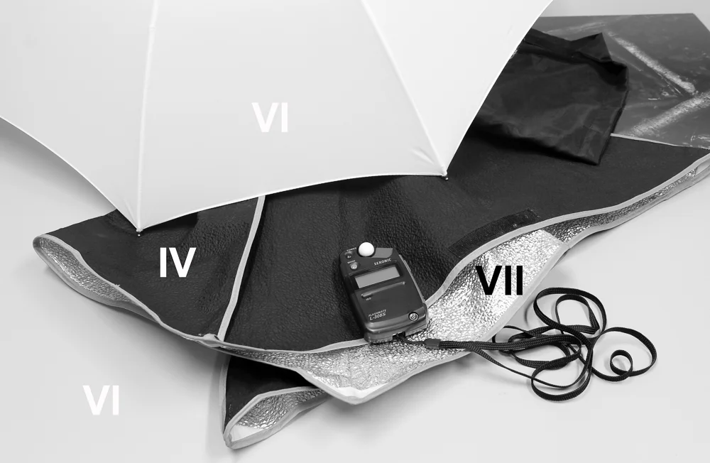 A one stop increase in exposure results in a ‘whiter’ umbrella, sitting on zone VI. Because we’ve now placed this on zone VI, the other areas we mentioned move up the scale accordingly: we’ve got a zone IV black area, a zone VII foil inner and a zone VI table top. We could place the umbrella on VII to visually bring it more in line with what a white umbrella should look like, but the consequence would be a mid-grey black area on the softbox cover, which is actually black. A zone system approach to the problem would be to go with the second of the two exposures, but increase development to make the umbrella lighter.